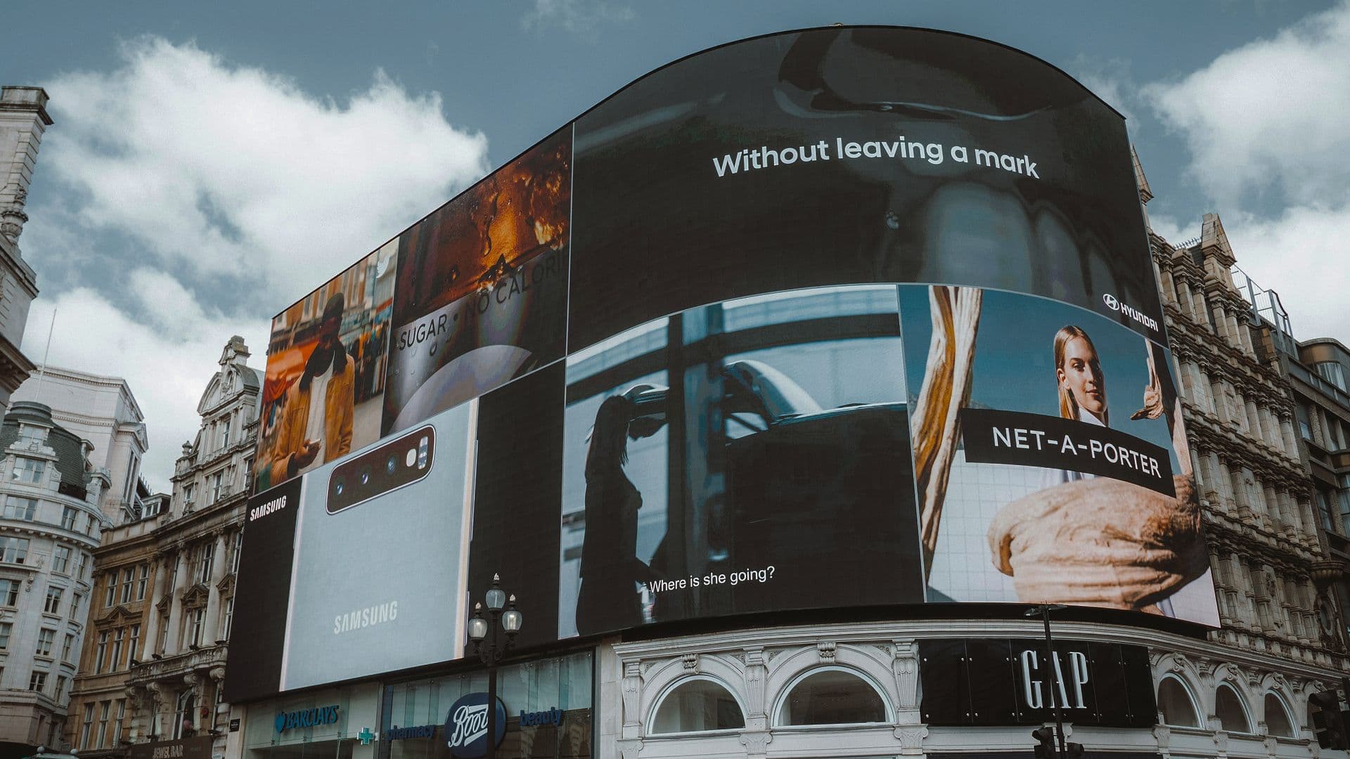 Große, geschwungene digitale Werbewand am Piccadilly Circus mit Anzeigen von Samsung, Hyundai und Net-A-Porter.