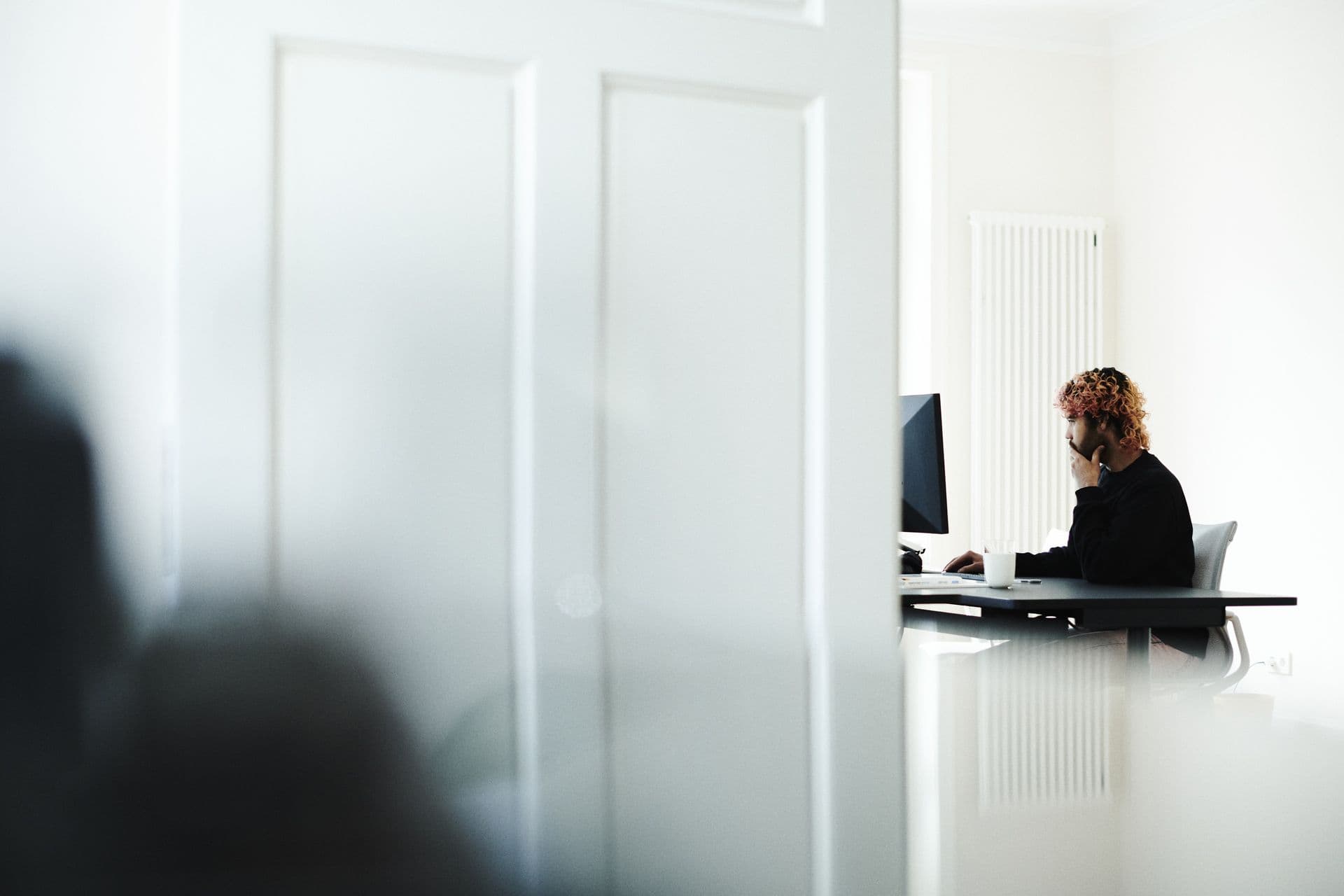 Person working focused at a desk in front of a monitor
