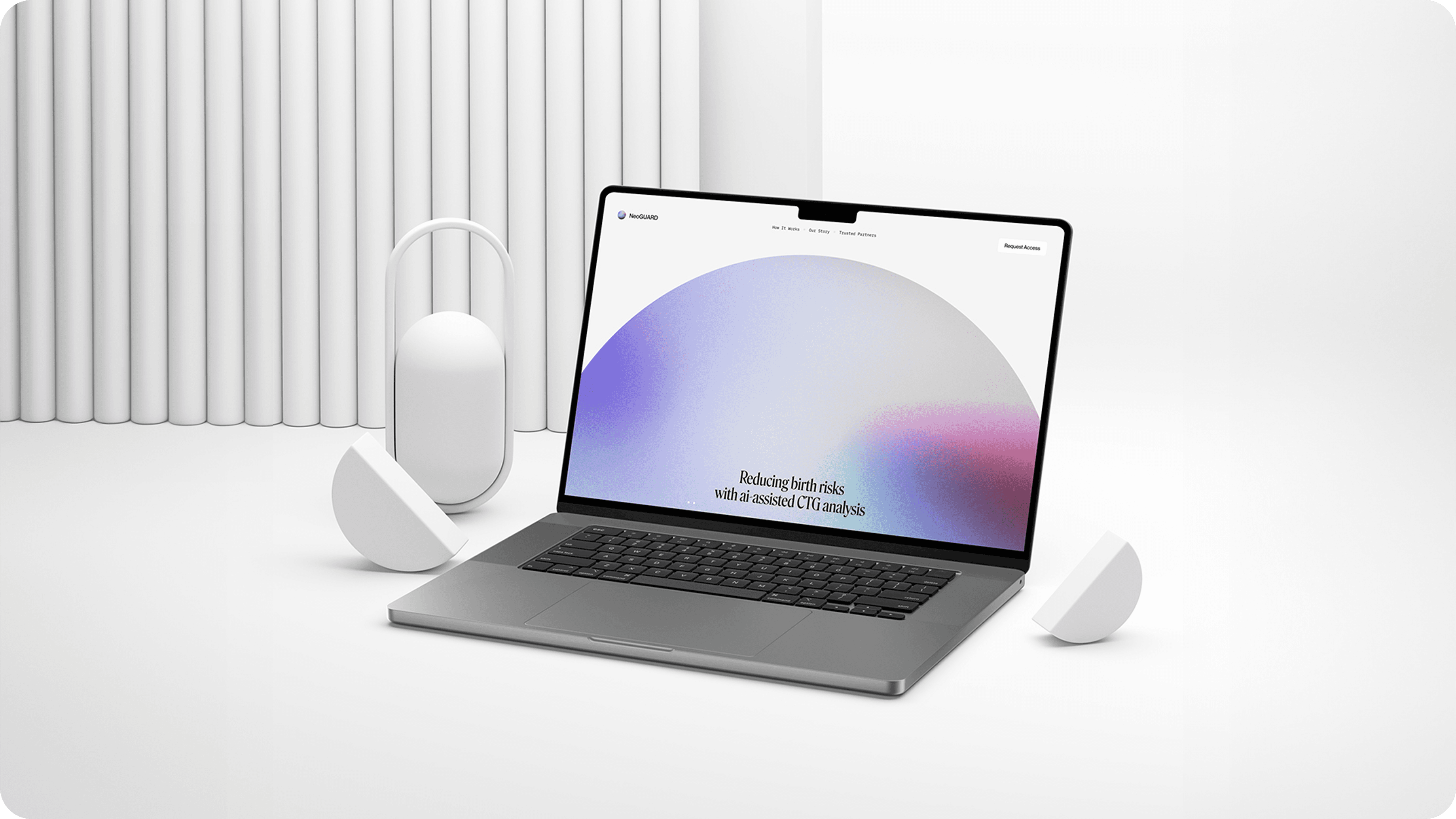 Laptop zeigt eine Website mit dem Text „Reducing birth risks“ und abstraktem Farbverlauf, umgeben von minimalistischen weißen Objekten.