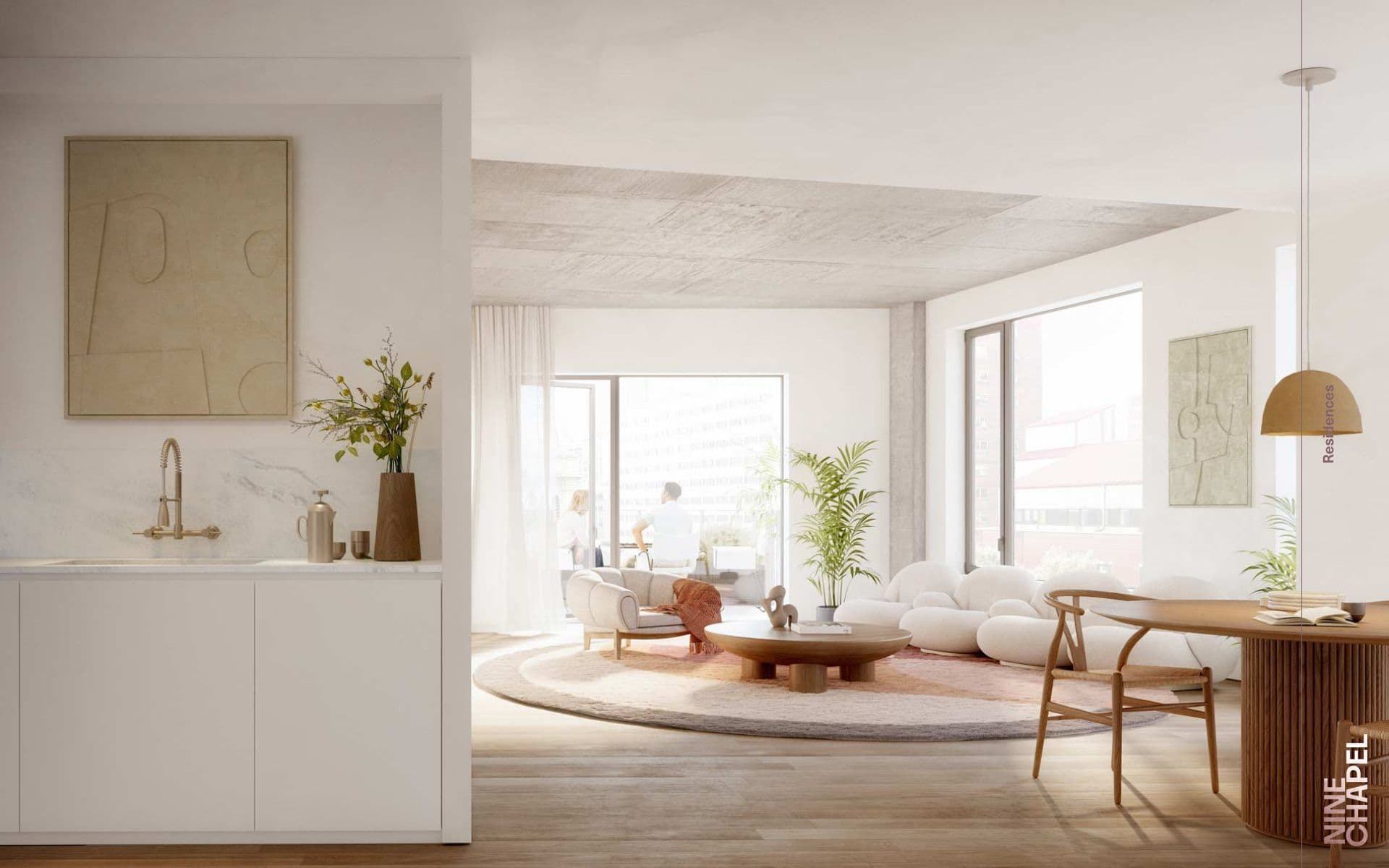 Bright, open-plan living space featuring a modern kitchen, white curved sofas, and a wooden dining table.